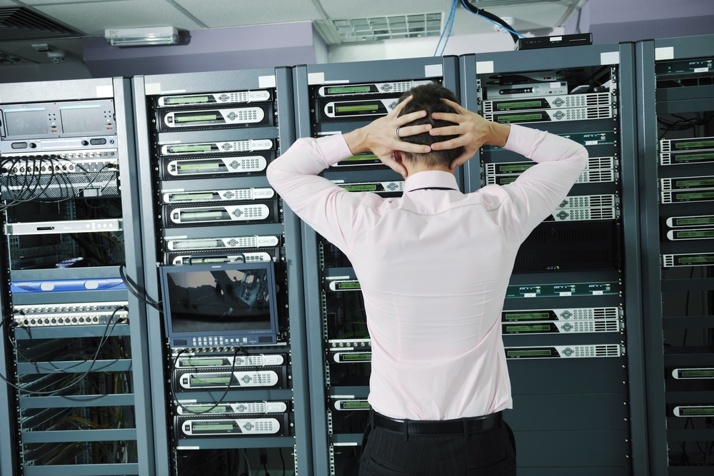 it business man in network server room have problems and looking for disaster situation solution